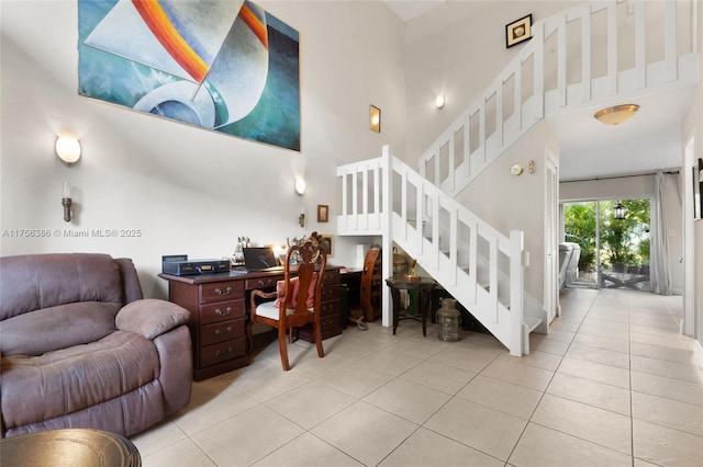 living area with stairs, a high ceiling, and light tile patterned flooring