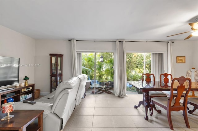 living area featuring a ceiling fan, a healthy amount of sunlight, and light tile patterned floors