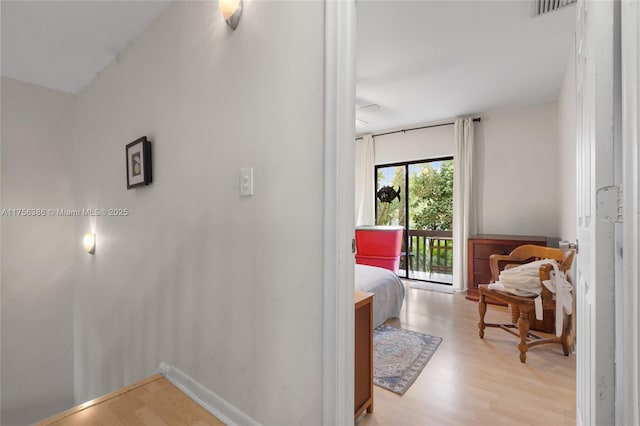 hall with light wood-style floors and baseboards