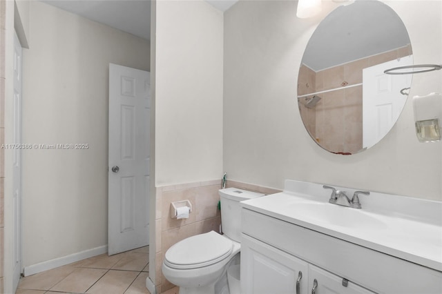 full bathroom featuring toilet, vanity, tile walls, and tile patterned floors