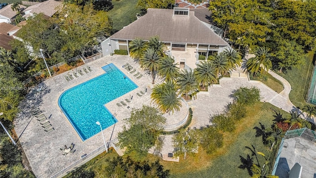 community pool with a patio and fence