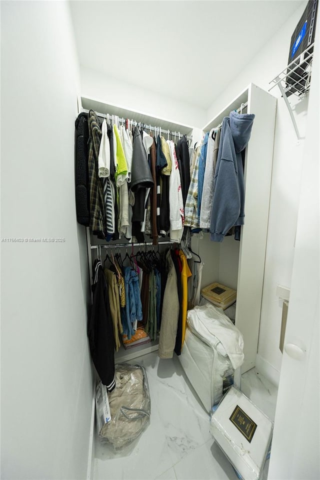 walk in closet with marble finish floor