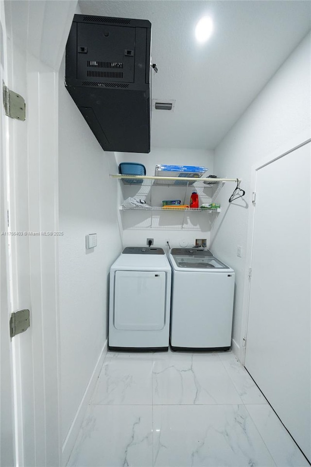 laundry room featuring marble finish floor, laundry area, separate washer and dryer, and baseboards