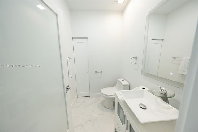 half bath with toilet, marble finish floor, baseboards, and vanity