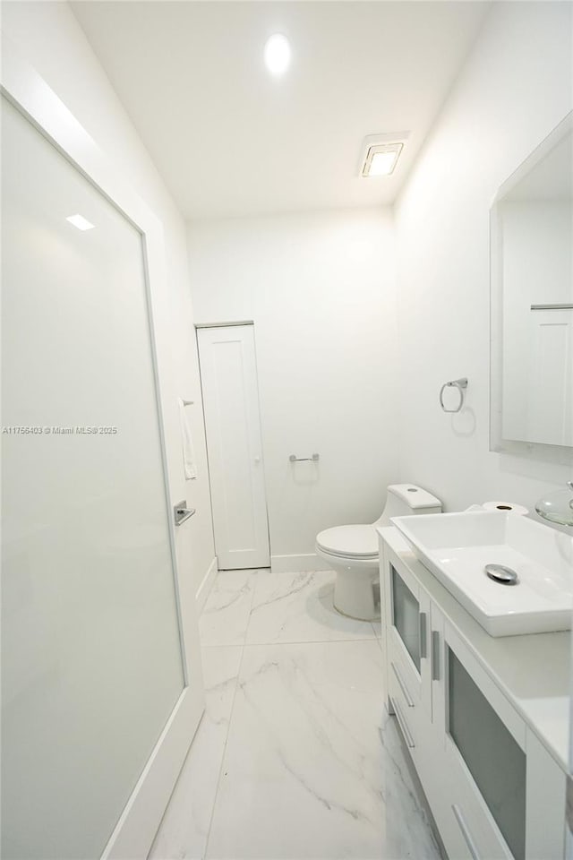 bathroom featuring marble finish floor, toilet, vanity, and baseboards