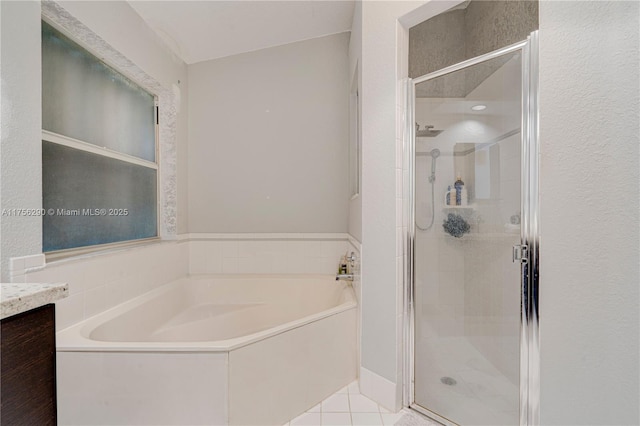 bathroom with tile patterned flooring, a shower stall, and a bath