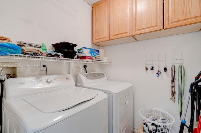 laundry room with independent washer and dryer and cabinet space