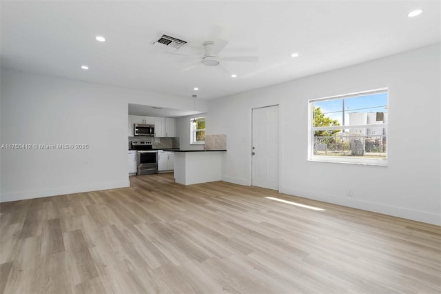 unfurnished living room featuring recessed lighting, visible vents, light wood-style flooring, and baseboards