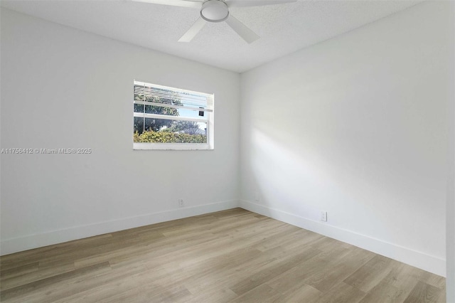 unfurnished room featuring light wood-type flooring, a textured ceiling, baseboards, and a ceiling fan