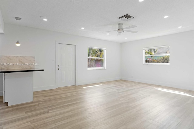 unfurnished room featuring recessed lighting, light wood-type flooring, visible vents, and baseboards