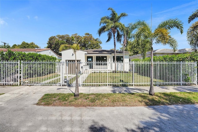 view of front of home featuring a front yard, a gate, a fenced front yard, and stucco siding