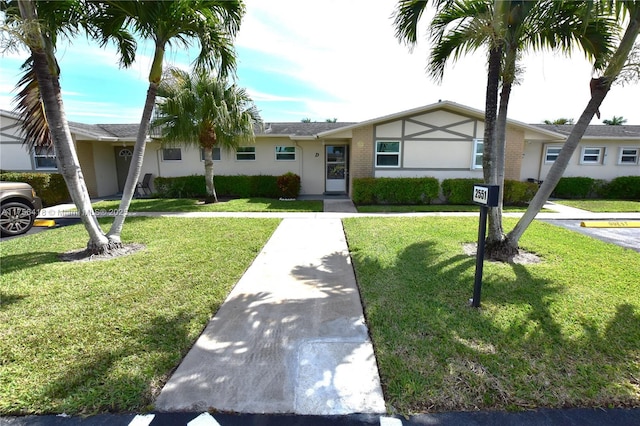 view of front facade with a front yard and stucco siding