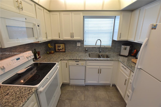 kitchen with white appliances, a sink, and white cabinetry