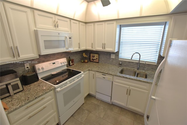 kitchen featuring white appliances, a sink, white cabinetry, and decorative backsplash