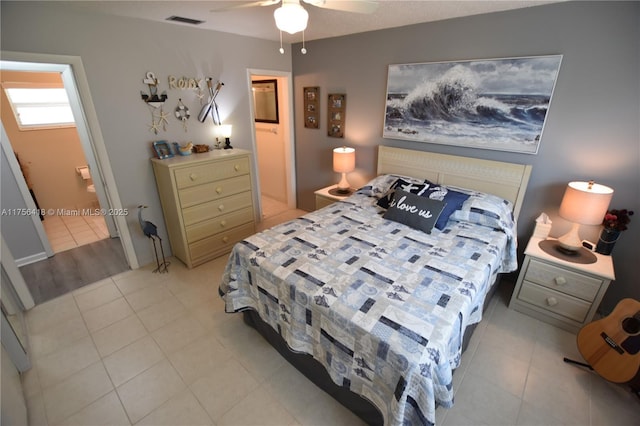 bedroom featuring ensuite bath, visible vents, and light tile patterned flooring