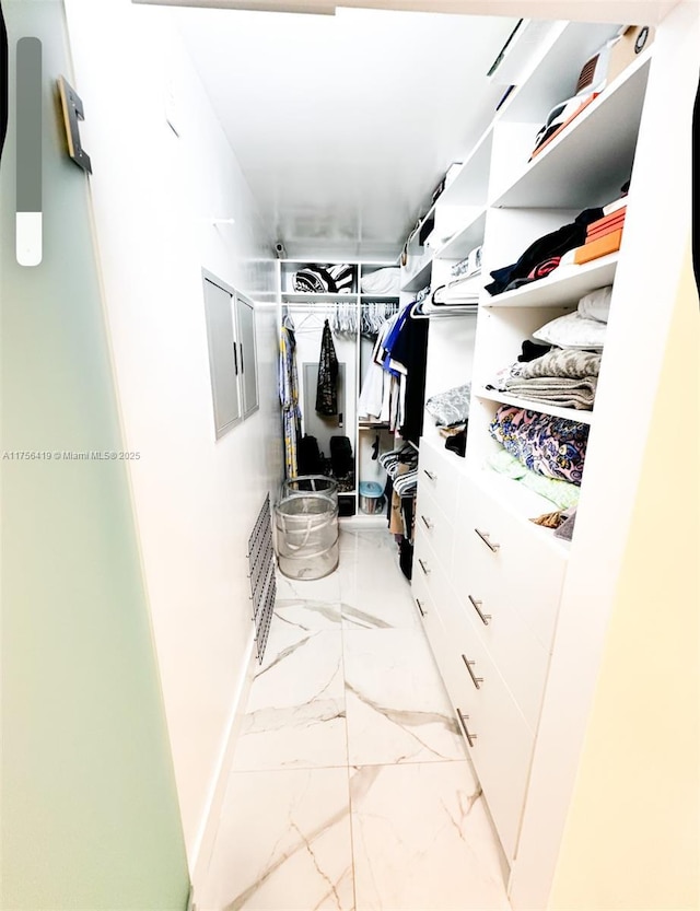 walk in closet with marble finish floor