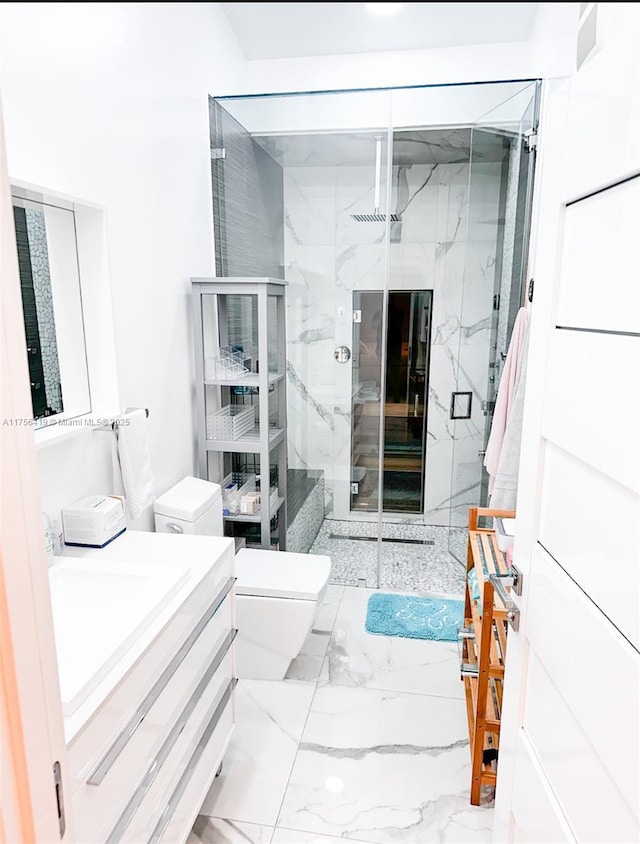 bathroom featuring toilet, marble finish floor, a marble finish shower, and vanity