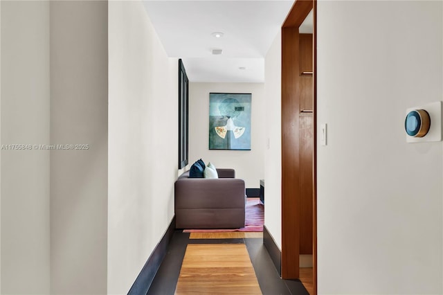 hall featuring wood finished floors and baseboards