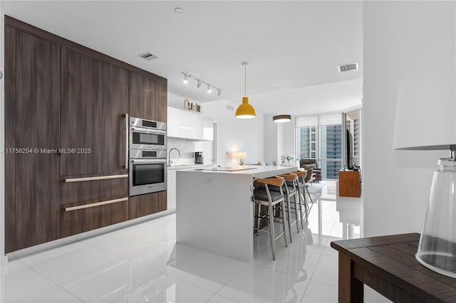 kitchen featuring floor to ceiling windows, light countertops, decorative backsplash, a kitchen island, and modern cabinets