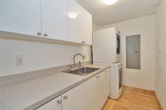 laundry area with cabinet space, electric panel, baseboards, stacked washing maching and dryer, and a sink