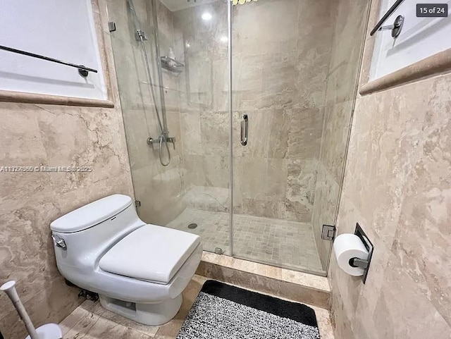 full bathroom featuring tile walls, a shower stall, and toilet