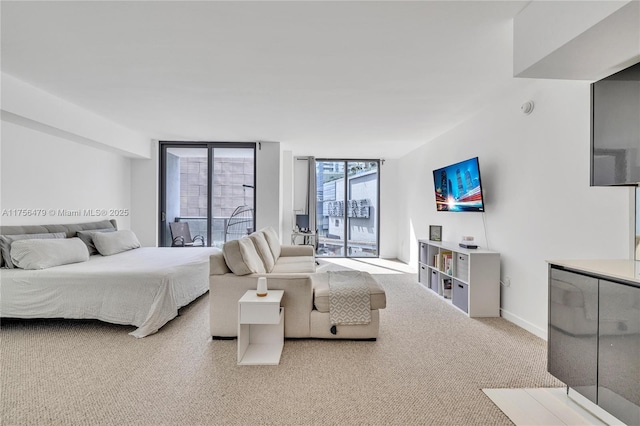 carpeted bedroom featuring floor to ceiling windows and baseboards