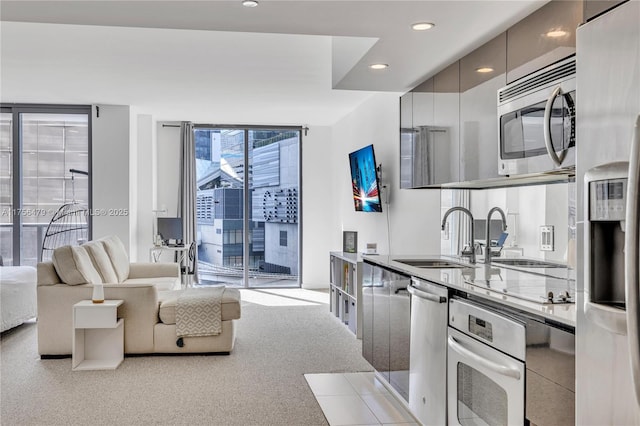 kitchen with recessed lighting, a sink, appliances with stainless steel finishes, floor to ceiling windows, and modern cabinets