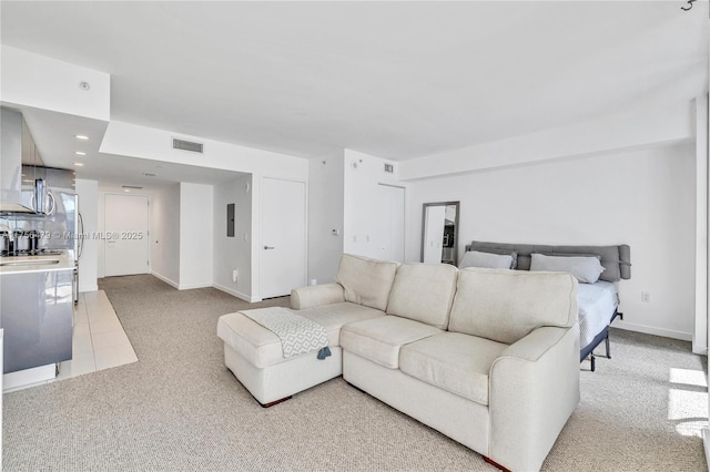 carpeted living area featuring baseboards, visible vents, and recessed lighting