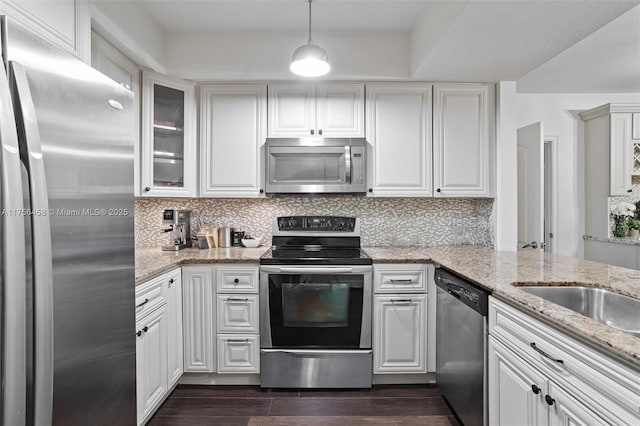 kitchen with light stone counters, white cabinetry, appliances with stainless steel finishes, backsplash, and dark wood-style floors