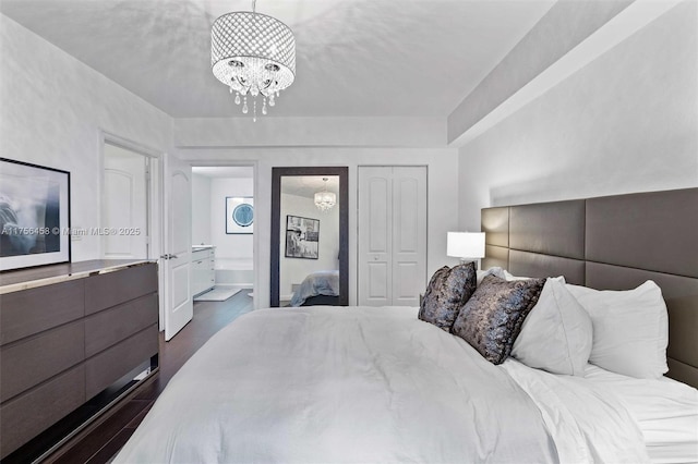 bedroom with an inviting chandelier, connected bathroom, dark wood finished floors, and a closet