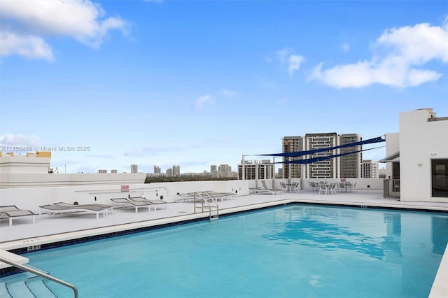 view of swimming pool featuring a patio area and a city view