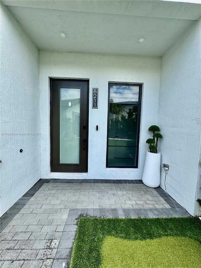 doorway to property featuring stucco siding