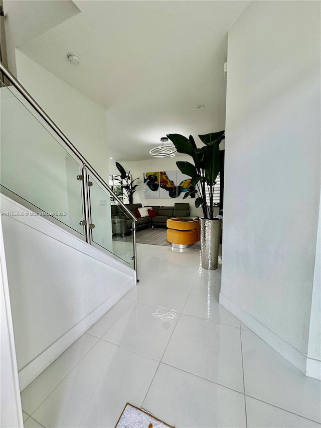 corridor featuring stairway and tile patterned floors