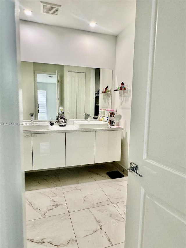 bathroom featuring marble finish floor, vanity, and visible vents