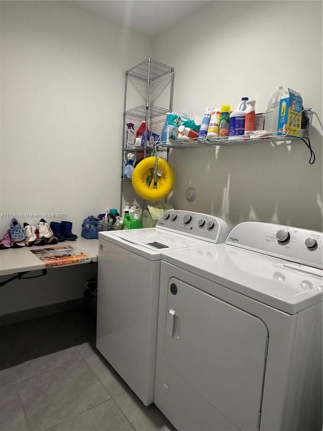 clothes washing area featuring laundry area, washer and clothes dryer, and light tile patterned floors