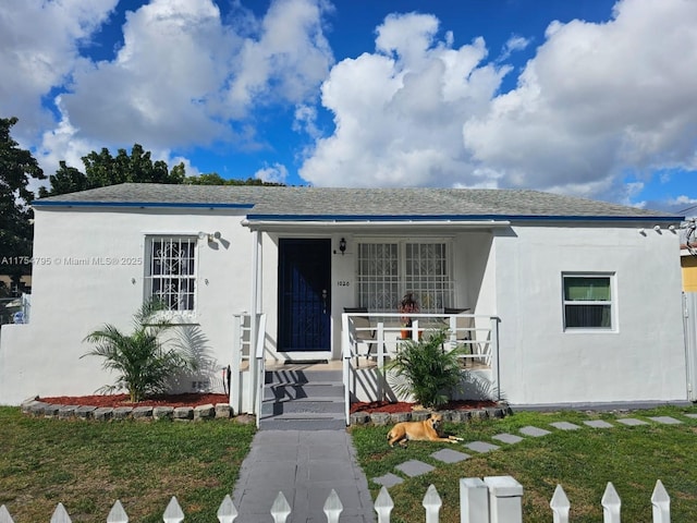 view of front of property with covered porch, a shingled roof, and stucco siding