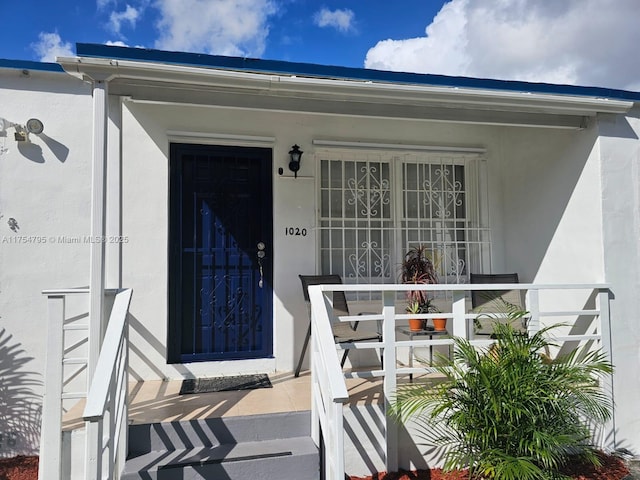 doorway to property featuring stucco siding