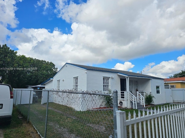 view of front of house with a fenced front yard, a front lawn, and stucco siding