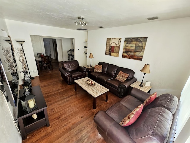 living area featuring visible vents and wood finished floors