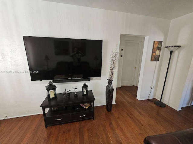 living area featuring baseboards and wood finished floors