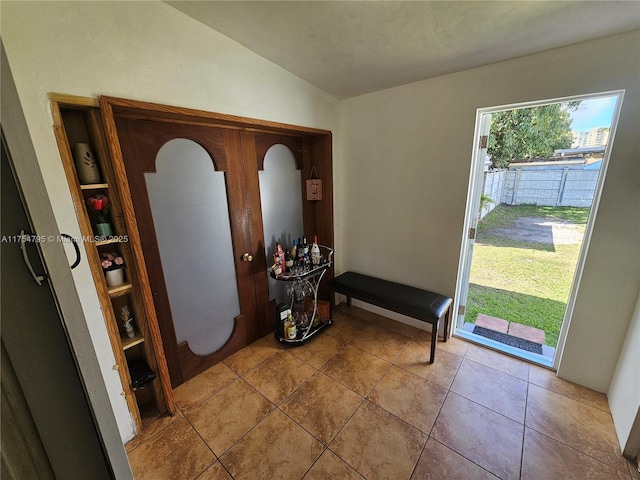 entryway with lofted ceiling and tile patterned floors