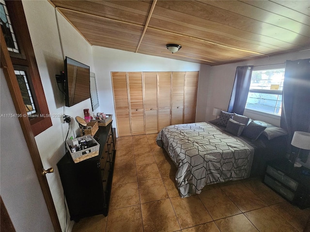 tiled bedroom with a closet, lofted ceiling, and wood ceiling