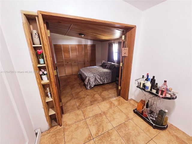 tiled bedroom with wooden ceiling and vaulted ceiling