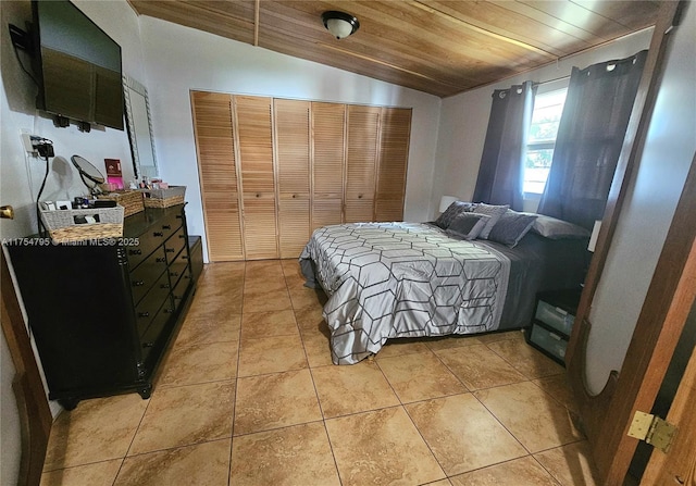 bedroom with a closet, lofted ceiling, wood ceiling, and light tile patterned floors