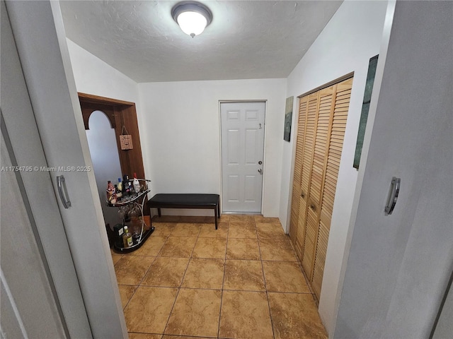 interior space featuring light tile patterned flooring and a textured ceiling