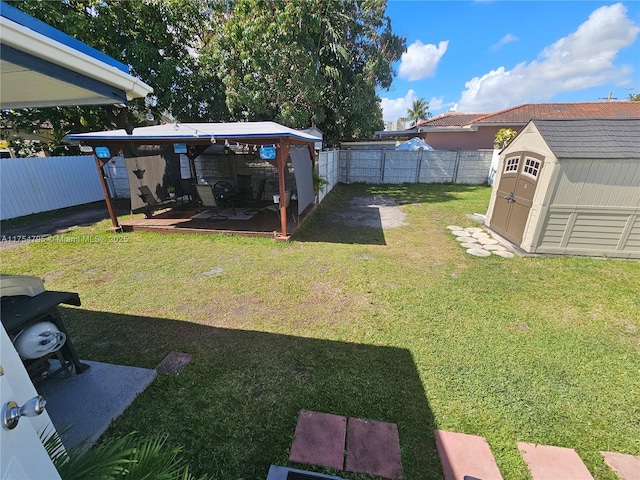 view of yard with an outbuilding, a fenced backyard, and a shed