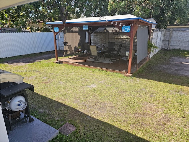 view of yard featuring a fenced backyard, a deck, and a gazebo