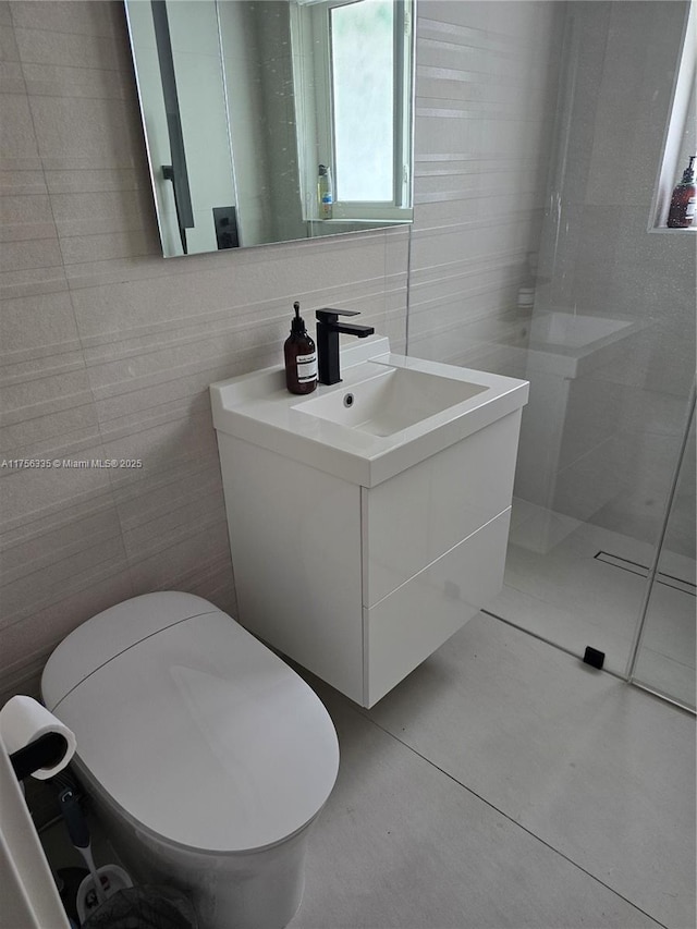 bathroom featuring toilet, a walk in shower, tile walls, and vanity