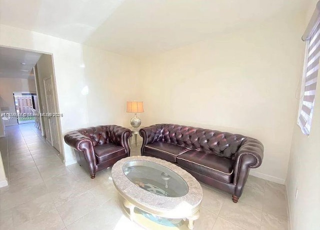 living area featuring light tile patterned floors and baseboards