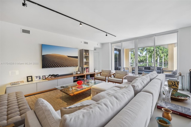 living area with expansive windows, visible vents, and track lighting